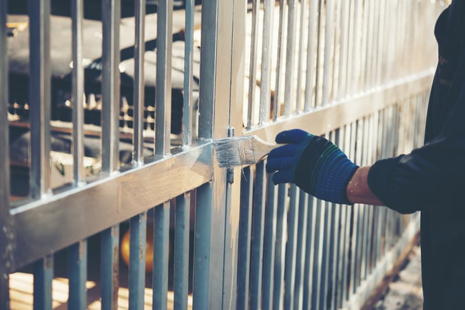 construction-worker-painting-fence-home